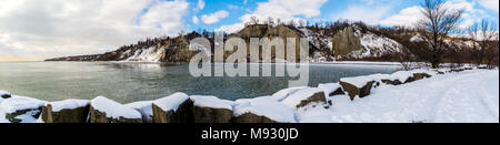 Scena invernale con scogliere crinali innevati con gelide acque del lago in un giorno nuvoloso Foto Stock