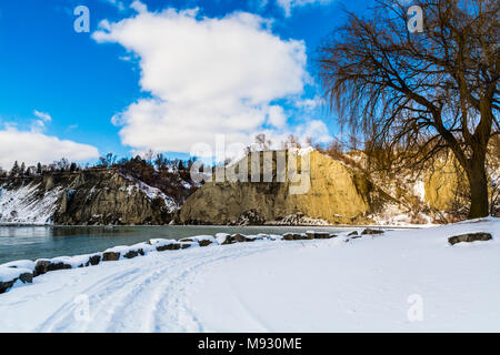 Scena invernale con scogliere crinali innevati con gelide acque del lago in un giorno nuvoloso Foto Stock