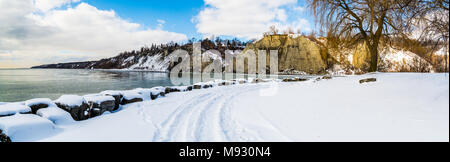 Scena invernale con scogliere crinali innevati con gelide acque del lago in un giorno nuvoloso Foto Stock