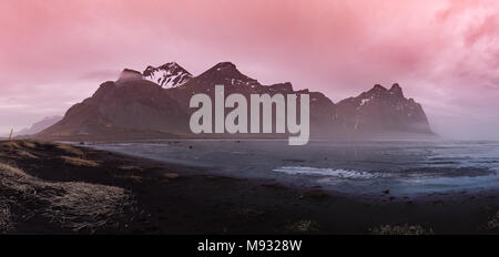 Vestrahorn Montagna in Islanda al tramonto con sabbia nera e un lago ghiacciato in primo piano Foto Stock