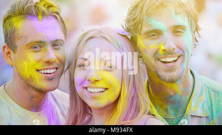 Amici sorridente al festival di colore celebrazione, divertirsi sul fine settimana estivo Foto Stock