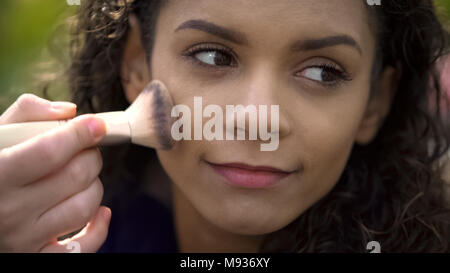 Bella faccia di bella donna sorridente attrice, make-up artist l'applicazione di polvere Foto Stock