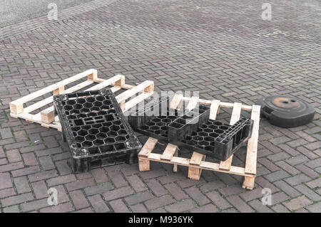 In plastica e pallet in legno sul terreno Foto Stock