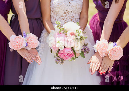 Le mani della sposa e fidanzata con fiori decorativi. Foto Stock