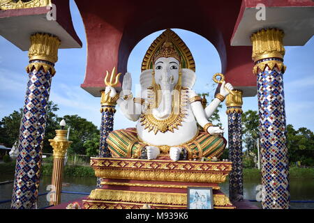 Ganesha elephant face statua in un Wat Plai Laem tempio buddista sotto un tetto poco supportato da 4 blu scolpito pilastri su un lago surrou sfondo Foto Stock