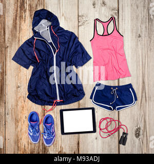 Abbigliamento sportivo e attrezzature su pavimento di legno. Foto Stock