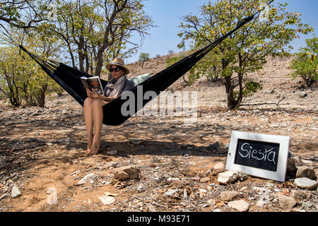 Donna relax in amaca - Huab sotto tela, Damaraland, Namibia, Africa Foto Stock