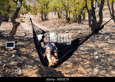 Donna relax in amaca - Huab sotto tela, Damaraland, Namibia, Africa Foto Stock