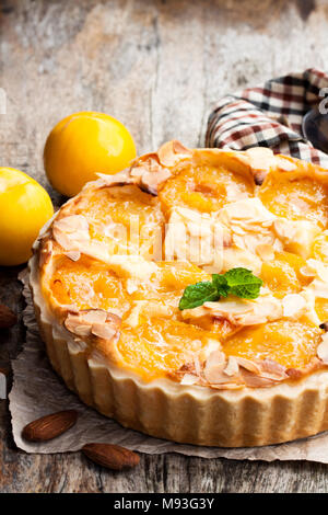 Deliziosa torta con prugna gialla e mandorle sul tavolo di legno Foto Stock