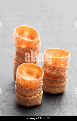 Pile di croustades pasticceria croccante casi sulla pietra nera sullo sfondo Foto Stock