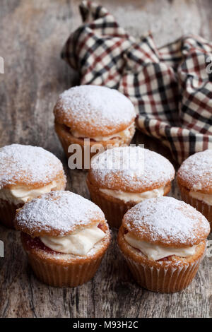 Tortine farcite con crema bianca sul tavolo di legno Foto Stock