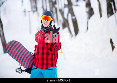 Foto di uomo sportivo indossando il casco con lo snowboard Foto Stock