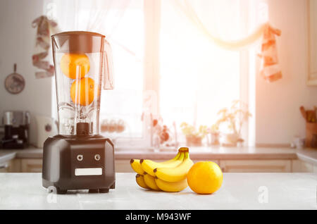Cibo di metallo blender close-up con fresca tropico Esotici frutti accanto ad essa su cucina sfondo con spazio vuoto. Frullatore e tavolo in legno in cucina. Su Foto Stock