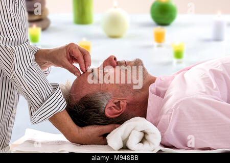 Vista laterale del senior rilassato uomo fronte di ricezione massaggio nella spa beaty salon Foto Stock