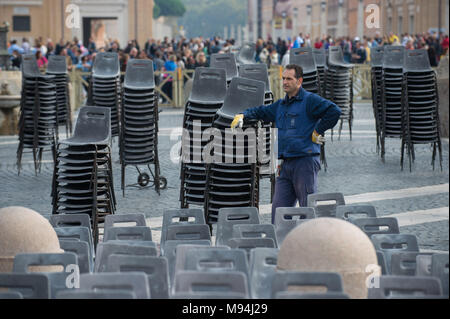 Città del Vaticano. Lavoratori disporre le sedie in aree destinate ai pellegrini, Piazza San Pietro. Vaticano. Foto Stock