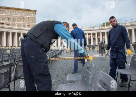 Città del Vaticano. Lavoratori disporre le sedie in aree destinate ai pellegrini, Piazza San Pietro. Vaticano. Foto Stock