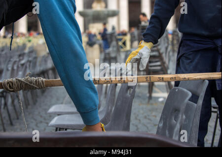 Città del Vaticano. Lavoratori disporre le sedie in aree destinate ai pellegrini, Piazza San Pietro. Vaticano. Foto Stock