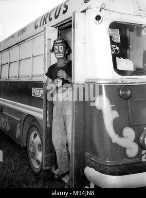 Un clown con il Christiani Fratelli Circus prende una pausa sigaretta backstage in Georgia, ca. 1955. Foto Stock