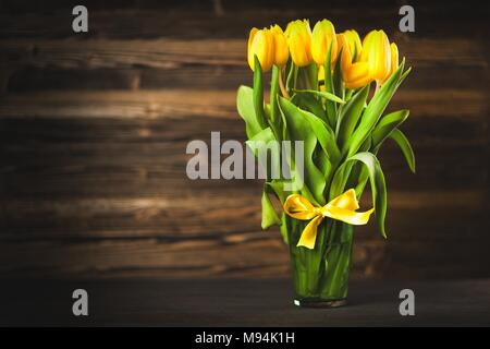 Tulipani gialli su sfondo di legno Foto Stock