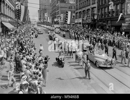 Il presidente Harry Truman onde provenienti dalla sua vettura durante la sfilata di un corteo verso il basso Grand Avenue nel centro citta' di Kansas City, Missouri nel 1947. Foto Stock
