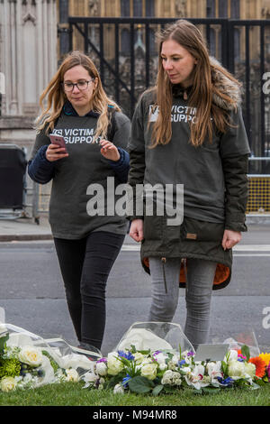 Londra, Regno Unito. Xxii marzo, 2018. Sostegno alle vittime sono a portata di mano in caso di aiuto è necessario - per il primo anniversario del Westminster Bridge attacco, omaggi floreali sono a sinistra su Piazza del Parlamento. Credito: Guy Bell/Alamy Live News Foto Stock