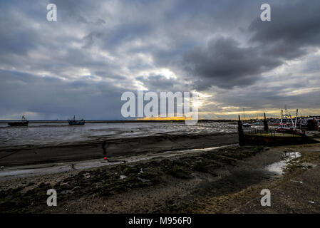 Il Cockle imbarcazioni a Leigh on Sea, Essex, al tramonto. La bassa marea sull estuario del Tamigi con il tramonto del sole Foto Stock