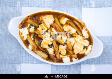 Ristorante delizioso poutine pasto sulla tovaglia pasto canadese fatta con patatine e salsa di cagliata di formaggio Foto Stock