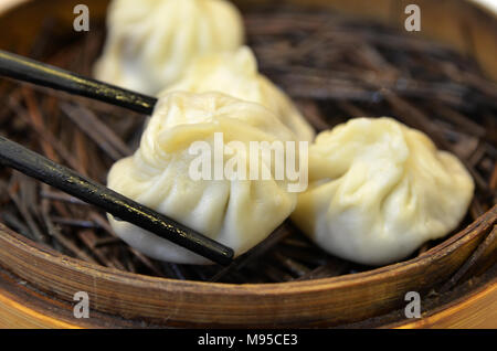 Zuppa tradizionale gnocco Xiao Long Bao è una popolare cinese di Shanghai dim sum a vapore in bamboo vaporizzatori. Foto Stock