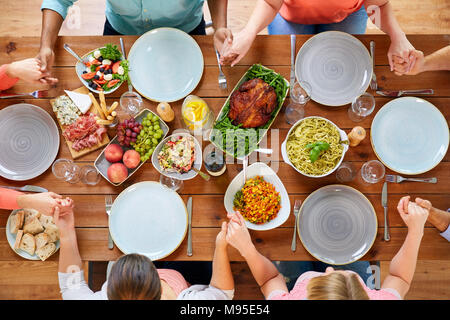 Gruppo di persone a tavola pregare prima del pasto Foto Stock