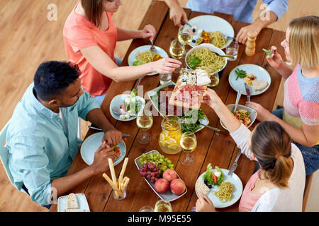 Gruppo di persone mangiare a tavola con i prodotti alimentari Foto Stock