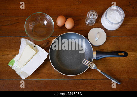 Preparazione di uova fritte su un tavolo di legno Foto Stock