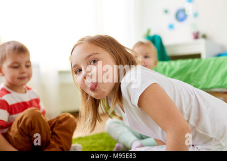 Ragazza che mostra la linguetta a casa Foto Stock