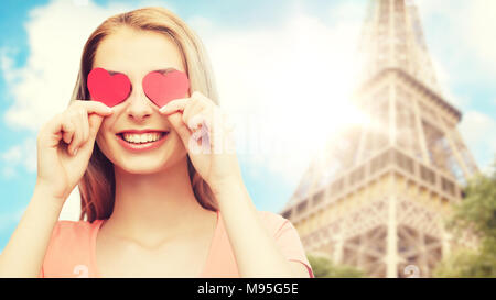 Felice giovane donna con cuore rosso forme su gli occhi Foto Stock