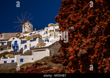 Un mulino a vento tradizionale si trova sulla cima di una scogliera bianca villaggio di Armeni, Santorini, Grecia Foto Stock