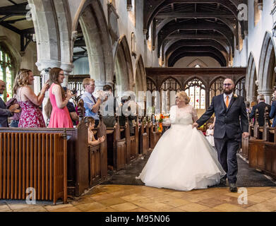 Sposa e lo sposo a piedi verso il basso corridoio dopo il matrimonio Foto Stock