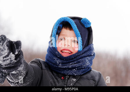 Ritratto di giovane ragazzo (5 anni) indossando inverno cappello e sciarpa Foto Stock