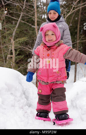 Una bambina di 3 anni di età) con le racchette da neve in Québec Canada Foto Stock