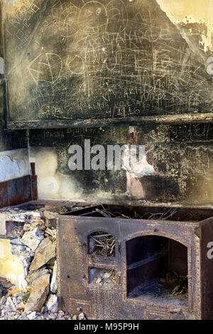 Cucina abbandonati. Cucina di zone depresse in disuso house con grungy pareti e la luce proveniente dalla finestra singola . Foto Stock