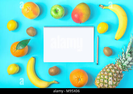 Varietà di differenti tropicale e stagionali estivi frutti. Ananas Manghi Agrumi Noce di Cocco Arance Limoni Mele Kiwi banane sparse sulla luce blu Ba Foto Stock