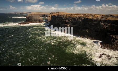 Onde che si infrangono contro le rocce in testa ad anello su Irlanda dalla costa atlantica della contea di Clare Foto Stock