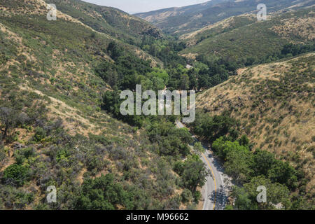 Stradina asfaltata che si snoda attraverso la valle e le colline della California del sud canyon. Foto Stock