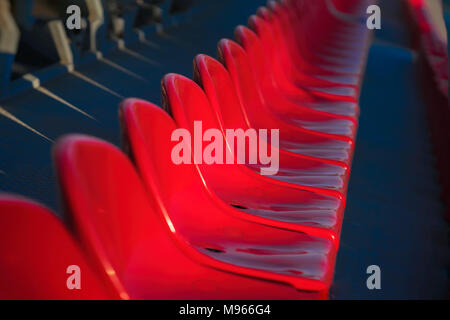 Righe di vuoto luminoso sedie in plastica, sedi di tribune sul Stadium, diagonal sfondo, il fuoco selettivo Foto Stock