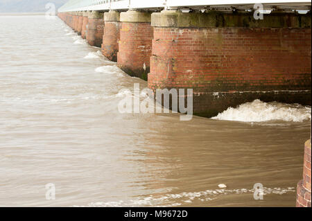 Una grande molla marea di allagamento incontro Arnside viadotto, Cumbria Inghilterra England Regno Unito. Arnside è situato sull'estuario del Kent che si restringe e risultati in forte Foto Stock