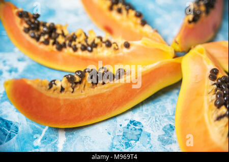 Succose fette di papaia matura su uno sfondo blu. Frutti Esotici, cibo sano. Foto Stock