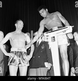 American campione del mondo dei pesi massimi boxer Muhammad Ali, precedentemente noto come argilla Cassio, raffigurato presso il cinema Odeon di Leicester Square durante la pesa per il suo titolo heavyweight lotta contro il Challenger britannici Henry Cooper (sinistra di Ali) presso lo stadio di Highbury, a nord di Londra. Ali ha vinto lo scontro al sesto giro quando l'arbitro ha dovuto interrompere la lotta a causa di una ferita profonda apertura sopra Cooper's occhio sinistro. Il 23 maggio 1966. Foto Stock