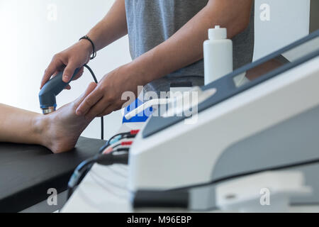 Elettrostimolazione utilizzati per trattare il dolore, muscoli lesioni, ceppi e tensione in ospedale medici fisioterapia clinica di riabilitazione per il ginocchio del paziente Foto Stock