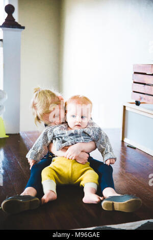Baby sitter a ragazza in giro essendo abbracciato Foto Stock