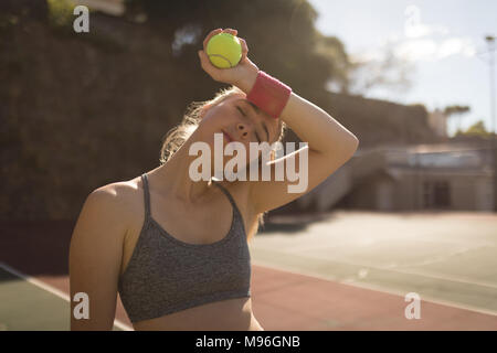 Donna sudorazione mentre giocando a tennis nel campo da tennis Foto Stock