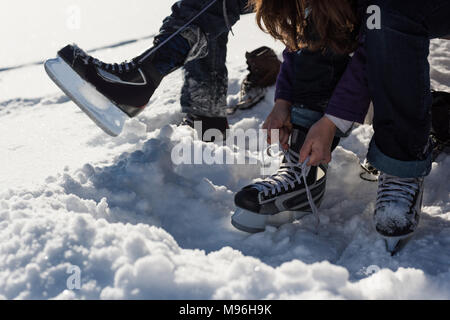 Giovane indossando snow skate nel paesaggio innevato Foto Stock
