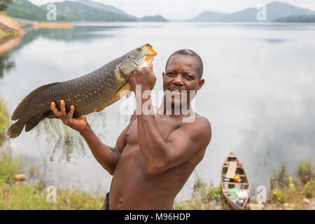 Kojo tenere la sua cattura sulla banca di Akosombo Dam, del Ghana meridionale. In Ghana, i bambini sono spesso dato un 'day' nome che corrisponde al giorno della settimana sono nati. Inoltre questi i nomi dei giorni hanno anche significati riguardanti l anima e il carattere di una persona. Per esempio, Kojo significa lunedì Nato e pace nel locale di lingua Akan. Foto Stock